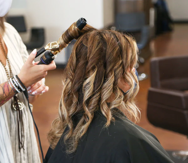 Curls being styled with a curling iron